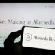 Crypto investment company, Alameda Research on screen in front of web page. Sumber: Shutterstock.